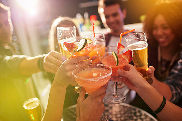 Shot Of A Group Of People Toasting With Their Drinks At A Nightclub
